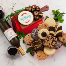 Cesta de regalo de cumpleaños con vino tinto y productos de panadería
