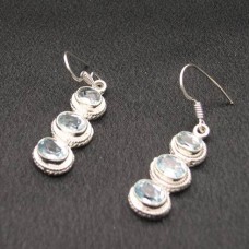 Pendientes de plata de ley y topacio azul facetado, elaborados por un artista.