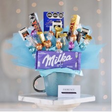 Ramo de dulces con bombones en una taza de cerámica grande.