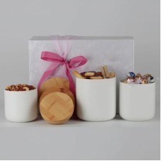 Regalo para ella con recipientes de cerámica y aperitivos gourmet.