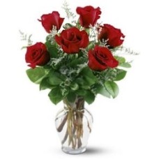 Arreglo de seis rosas en un jarrón de cristal