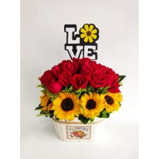 Arreglo floral con rosas y girasoles.