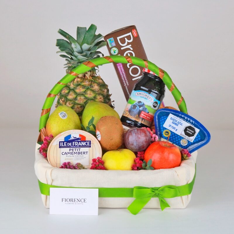 Cesta de regalo gourmet con frutas, quesos y galletas.