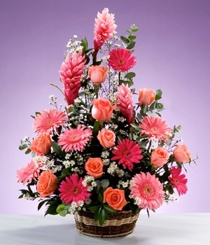 Arreglo floral con gerberas y rosas rosadas.