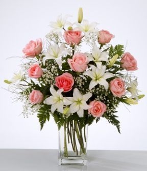 Arreglo floral en jarrón con lilium blanco y rosas rosadas.