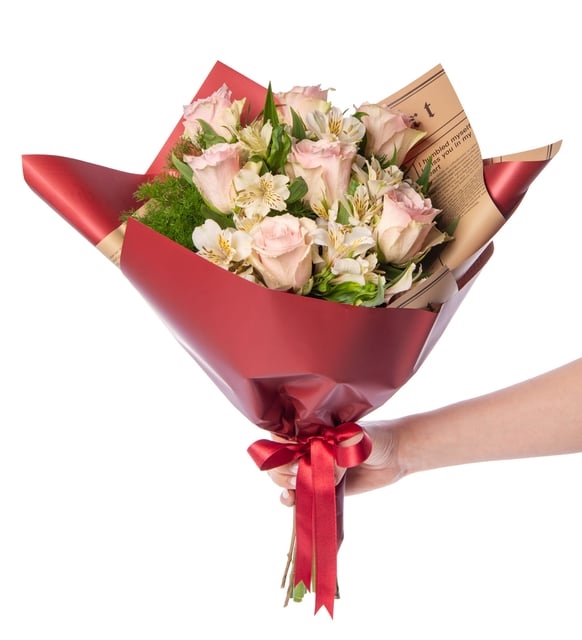 Ramo de astromelia blanca y rosa rosa en papel de periódico burdeos