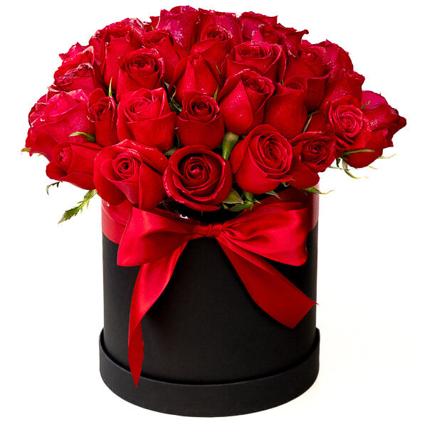 Rosas rojas en caja redonda negra alta.