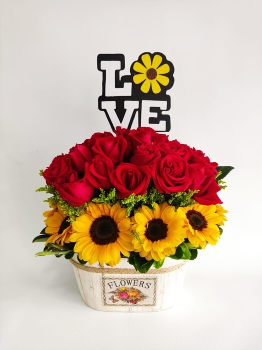 Arreglo floral con rosas y girasoles.
