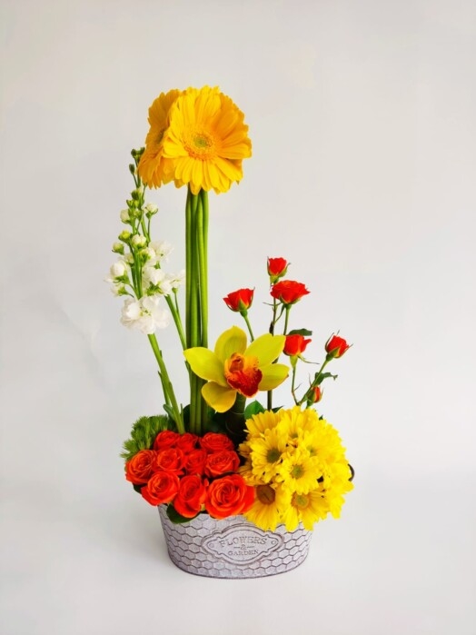 Hermosa orquídea con rosas, mini rosas, gerberas y margaritas.
