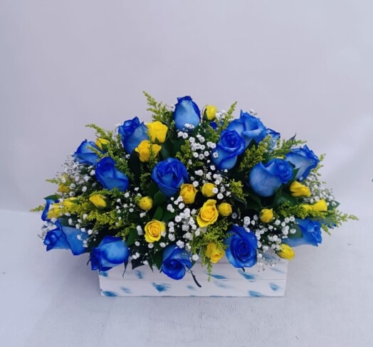 Arreglo floral con rosas azules y mini rosas.